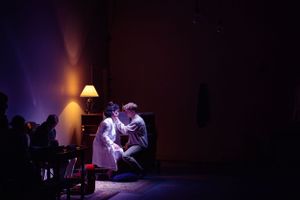 A tender moment captured during a theatrical performance under warm spotlight. From Mary's Wondrous Body in 2022.