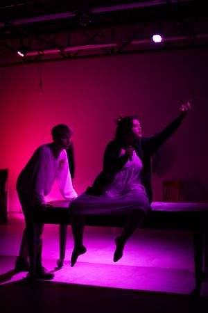 Performers create dynamic poses on stage under dramatic pink and purple lighting. From Mary's Wondrous Body in 2022.