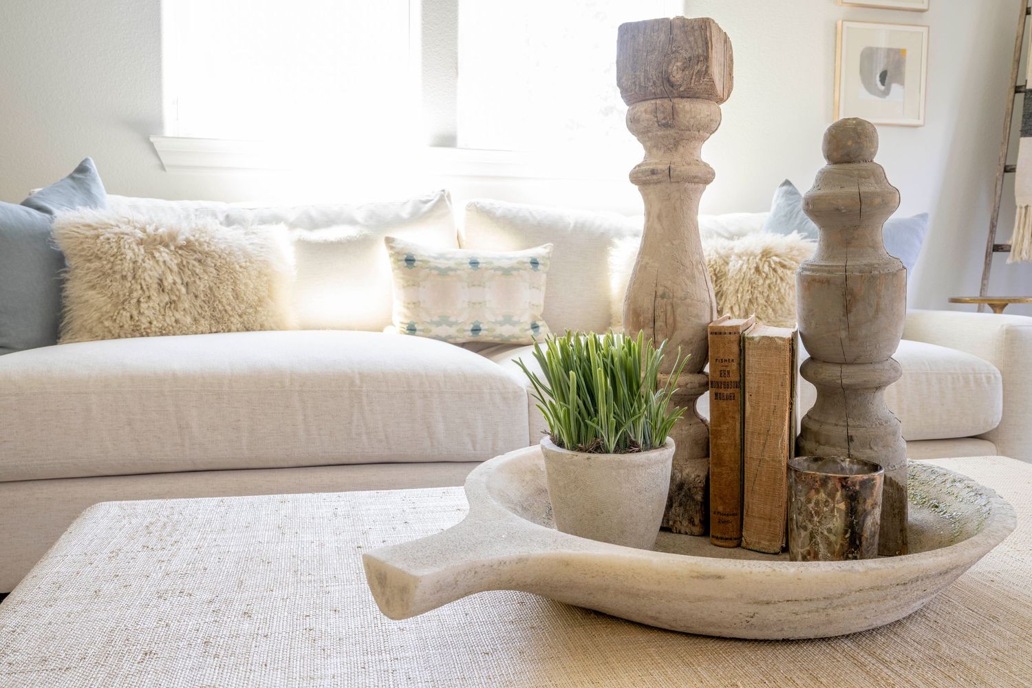 Cozy living room vignette with candlesticks, books and potted grass on a white ceramic tray. Interior Design, NJ Photo
