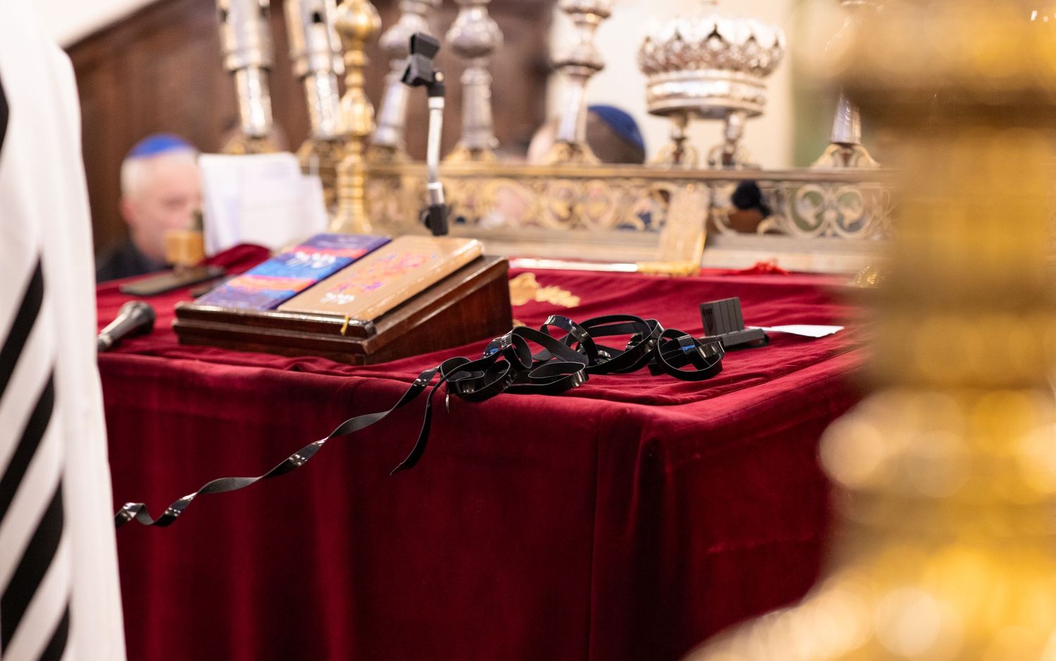 Religious artifacts and Torah accessories displayed on red velvet cloth.
