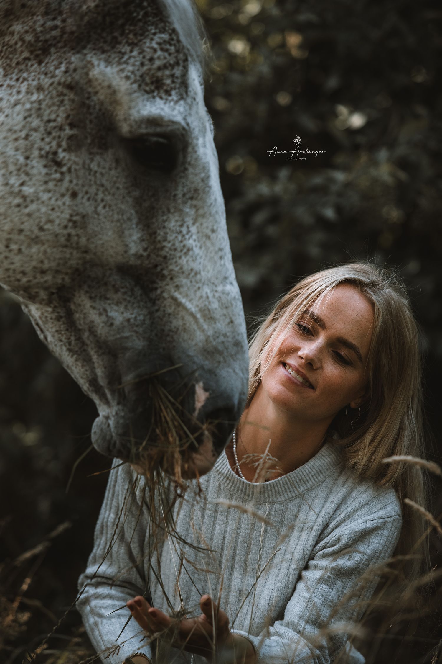Close up of tender interaction with gray horse in natural lighting.