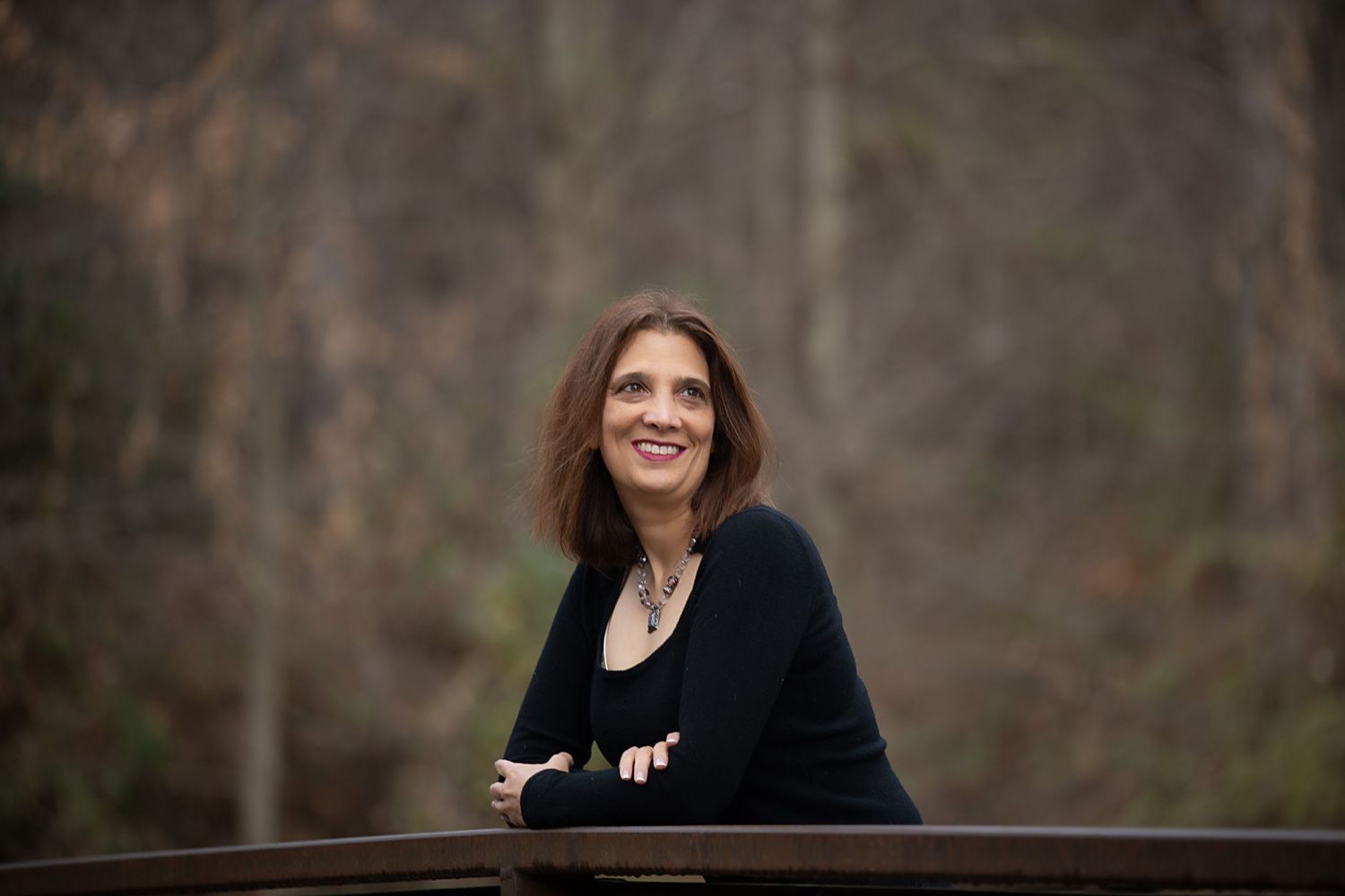 Candid outdoor photography session showing black sweater against natural background.
