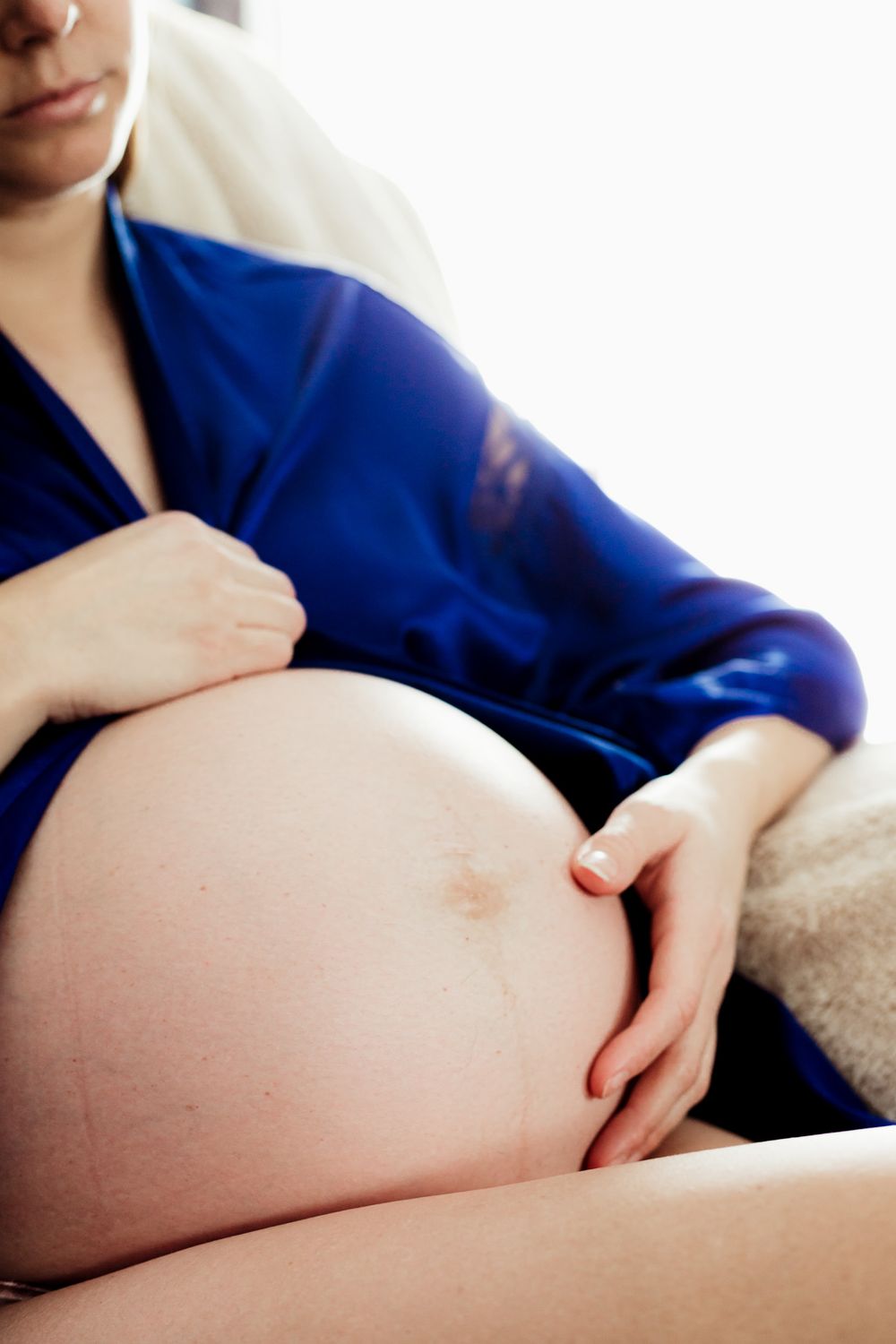 Mom touching her pregnant belly.