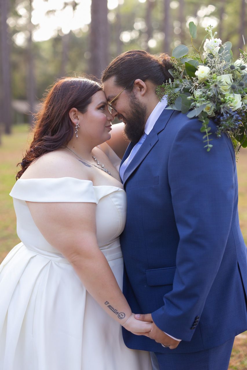 Wedding couple sharing intimate moments in a pine forest with floral decorations.
