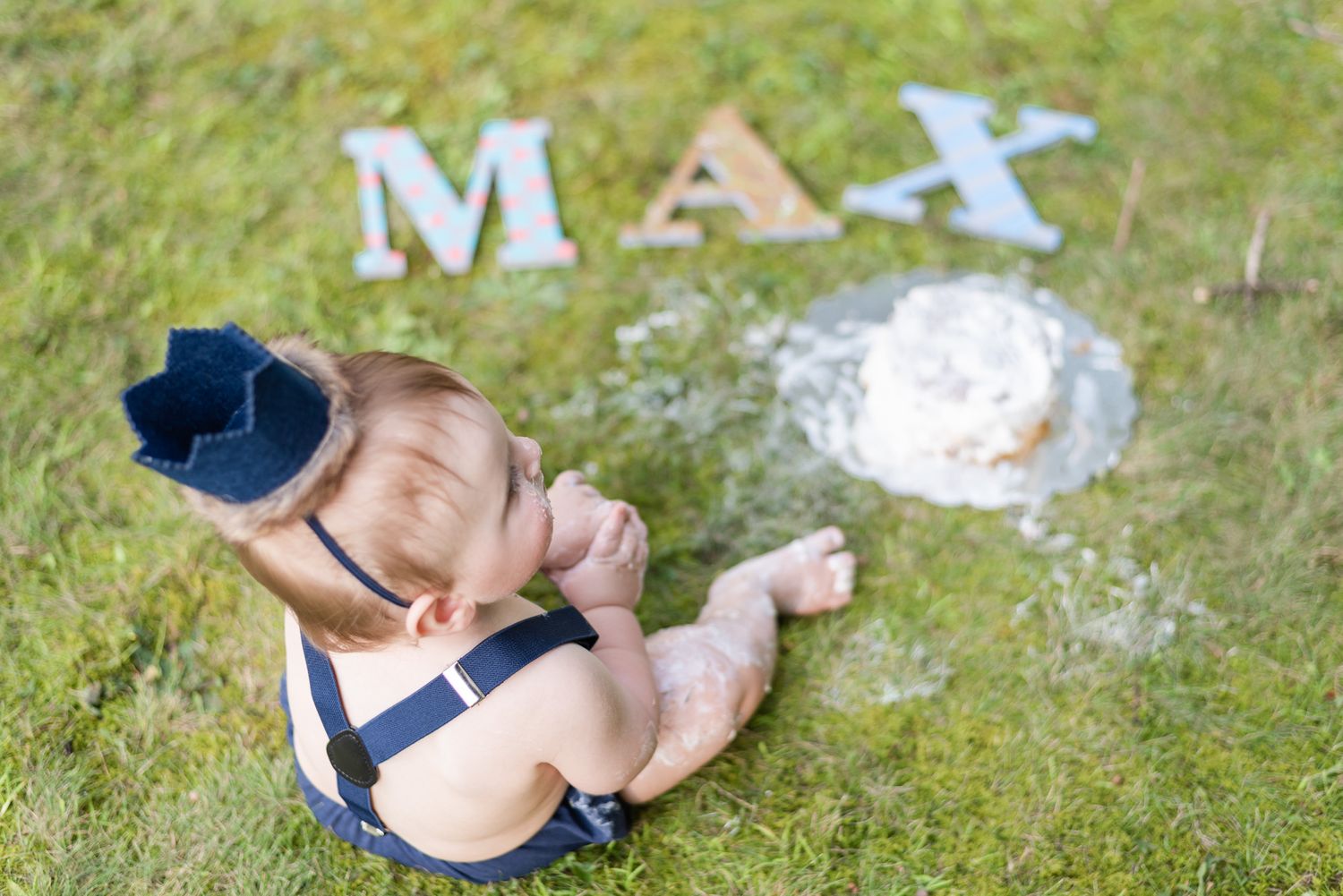 Baby sitting with cake in grass in Pittsburgh, Pennsylvania