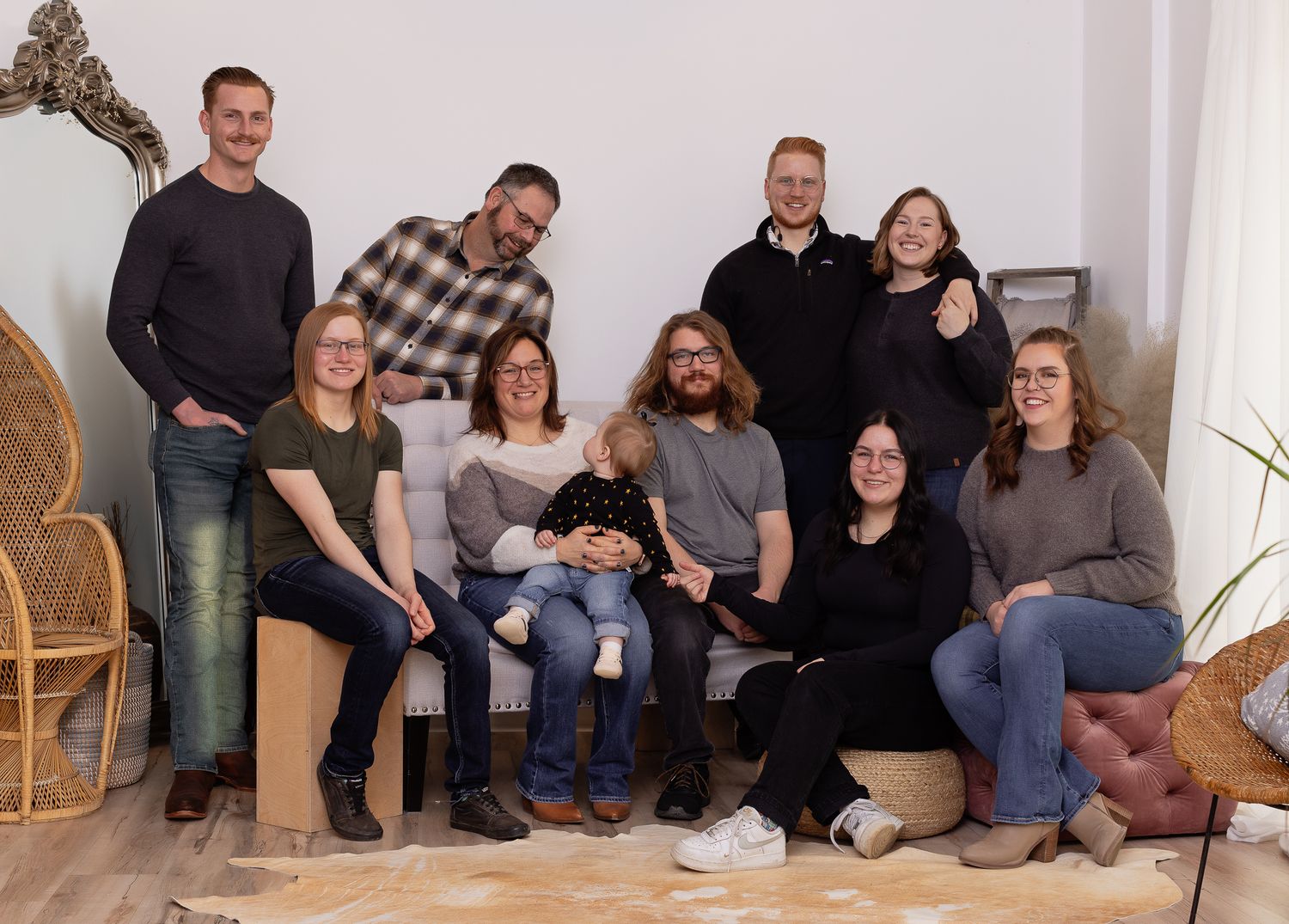 Interior lifestyle portrait of people sitting together on woven furniture in a bright studio space.