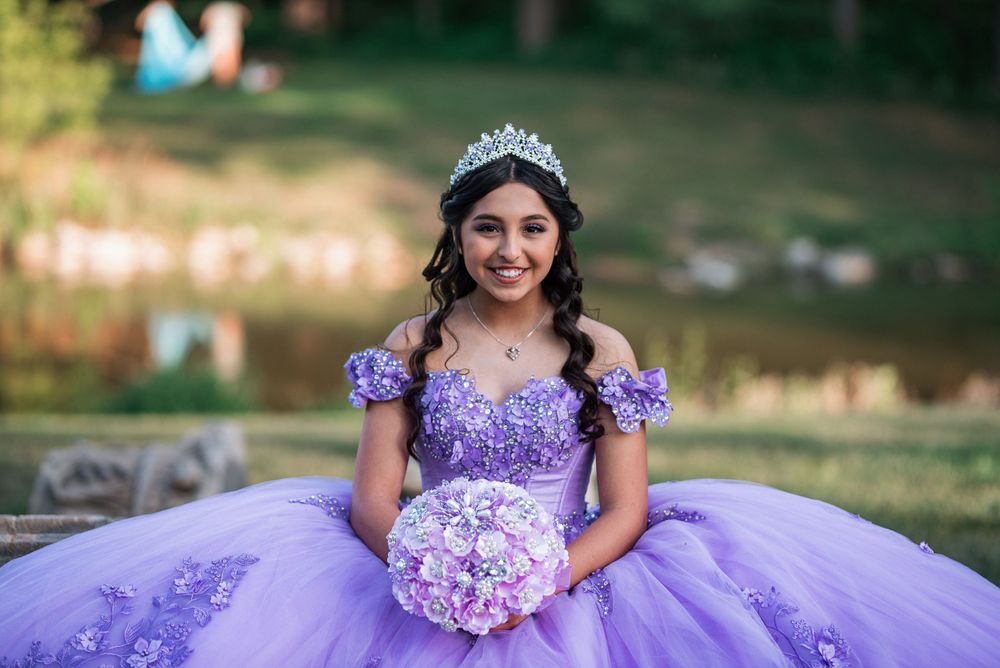 A stunning purple princess dress with a full tulle skirt photographed by a lake.