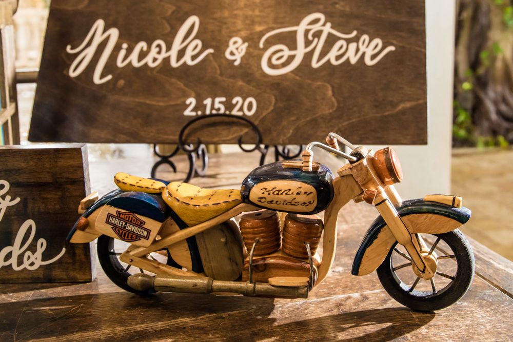 Vintage motorcycle decorations and signage displayed at a rustic wedding reception.
