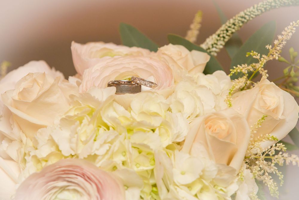 Elegant white and cream floral arrangements with greenery for a wedding.