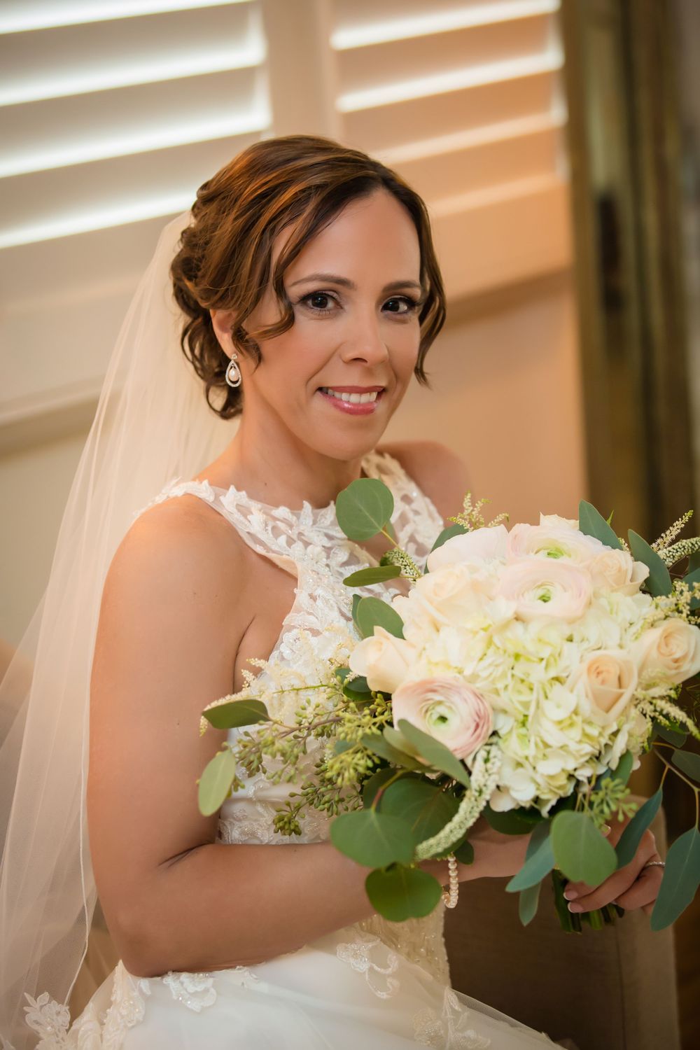 Wedding bouquet featuring white hydrangeas, roses and eucalyptus leaves.