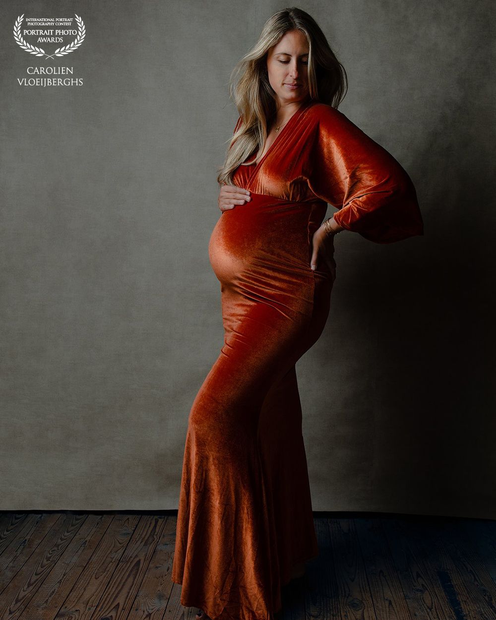 Portret award van zwangere vrouw in oranje/rode jurk