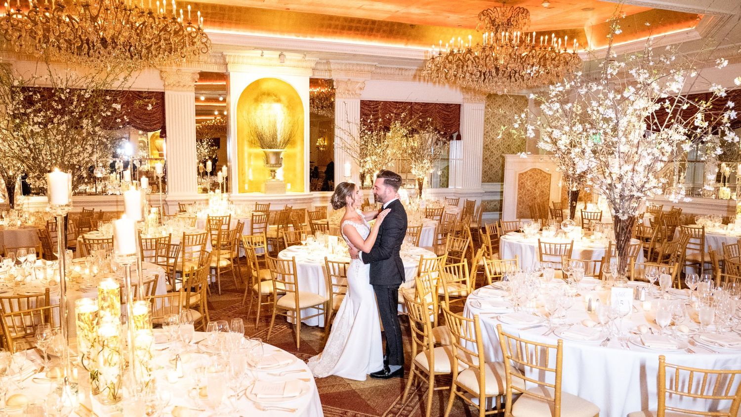 A loving couple, gazing into each other's eyes in the midst of the reception hall before commencing their celebration.