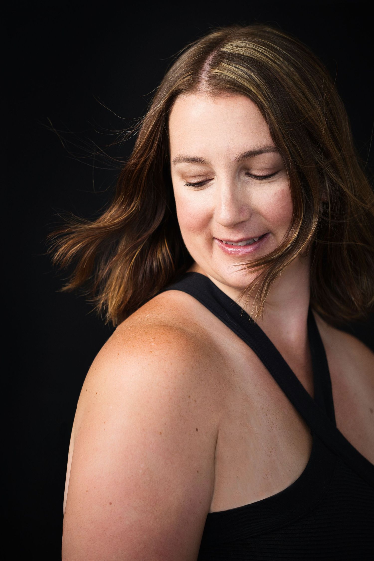 Portrait d'une femme heureuse sur un fond noir. Portrait of a happy woman on a black background.