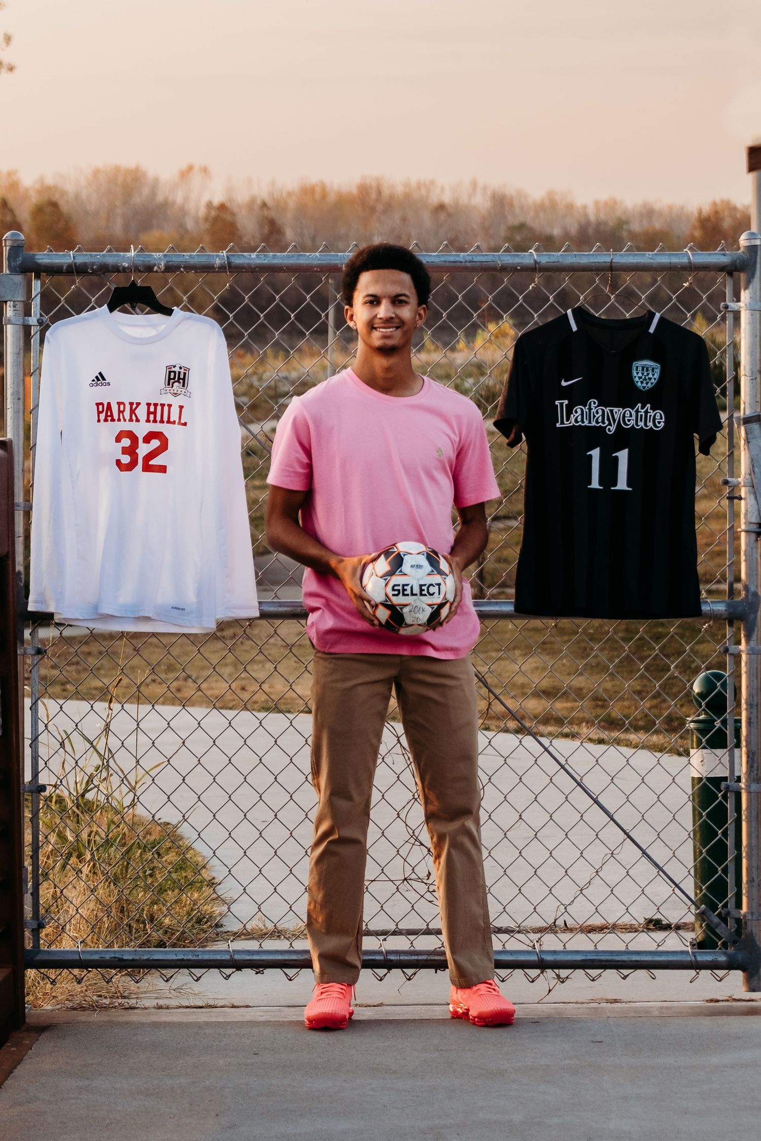High School senior standing with a soccer ball during a photography session in St. Joseph, Missouri.