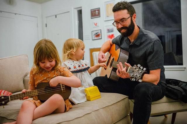 A cozy indoor scene of music making with guitars on a comfortable couch.