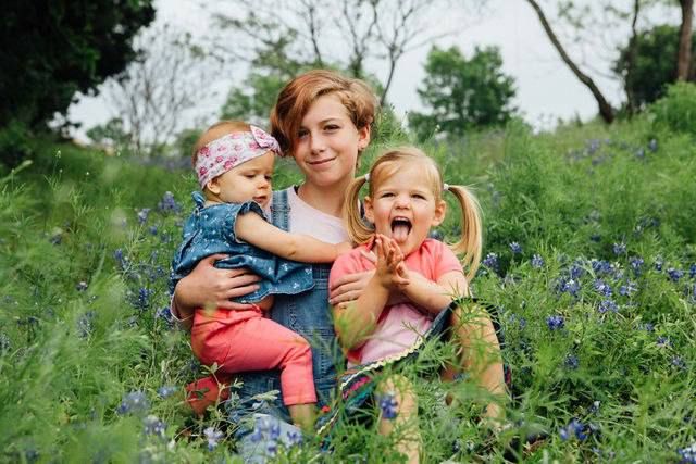 A cheerful spring portrait in a field of bluebonnets with expressions of joy and laughter.