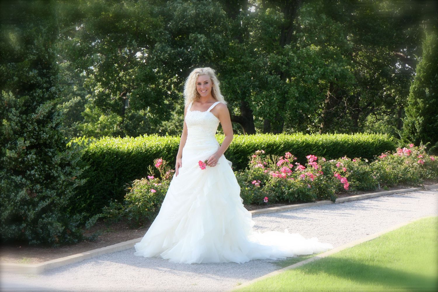 Beautiful white wedding dress flowing in a lush garden setting with vibrant greenery.