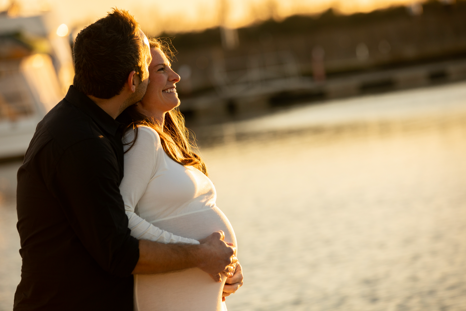 pregnant couple at the marina at sunset