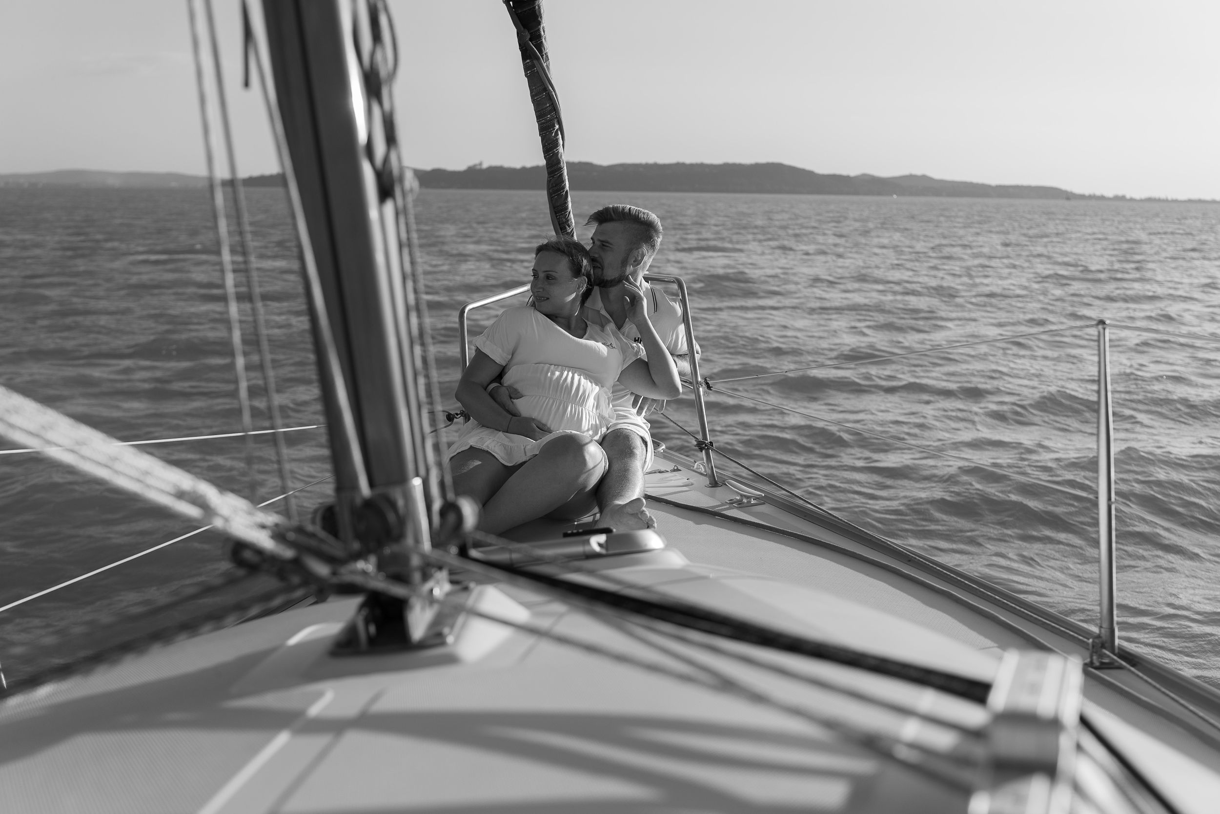 A black and white photograph of a couple sailing together on a yacht.