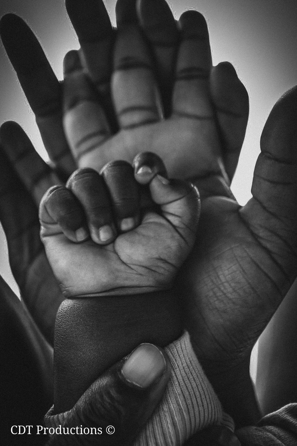 Family photography, a picture of a family with their hands on frame, showing their bond and a new born baby has been added to that family.