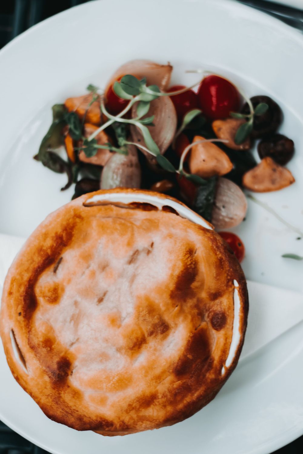 Food photography, pastry on a white plate with some vegetables.