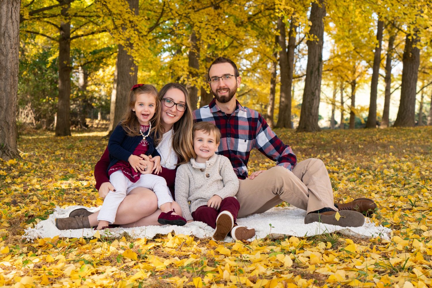 family smiles amongst the fall foliage at the VA State Arboretum