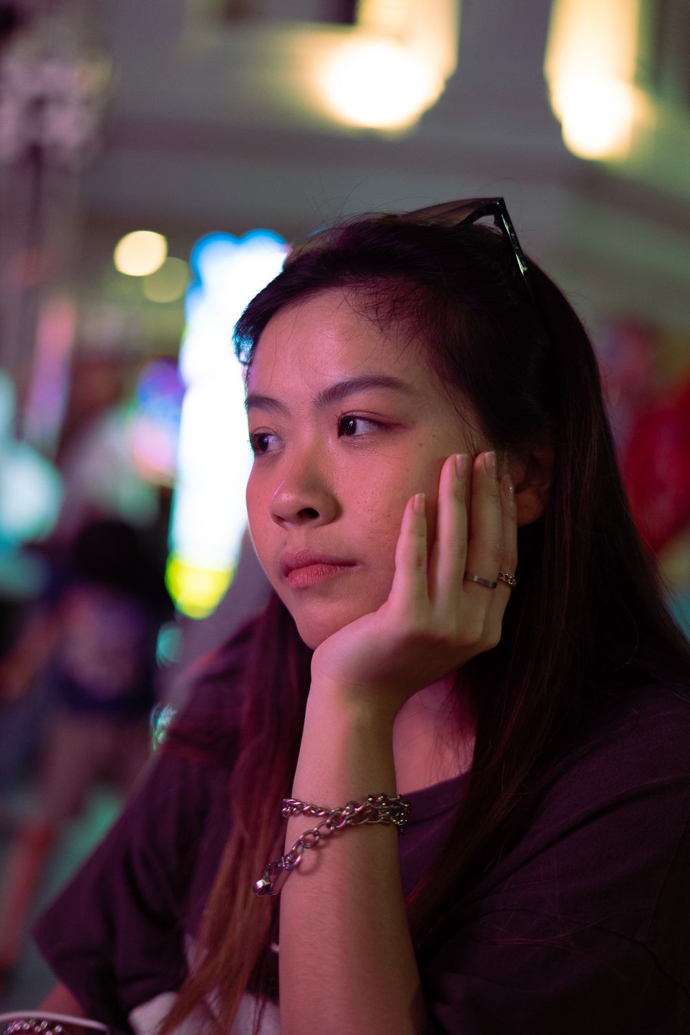 A contemplative moment captured during an evening event with ambient lighting and bokeh effects.