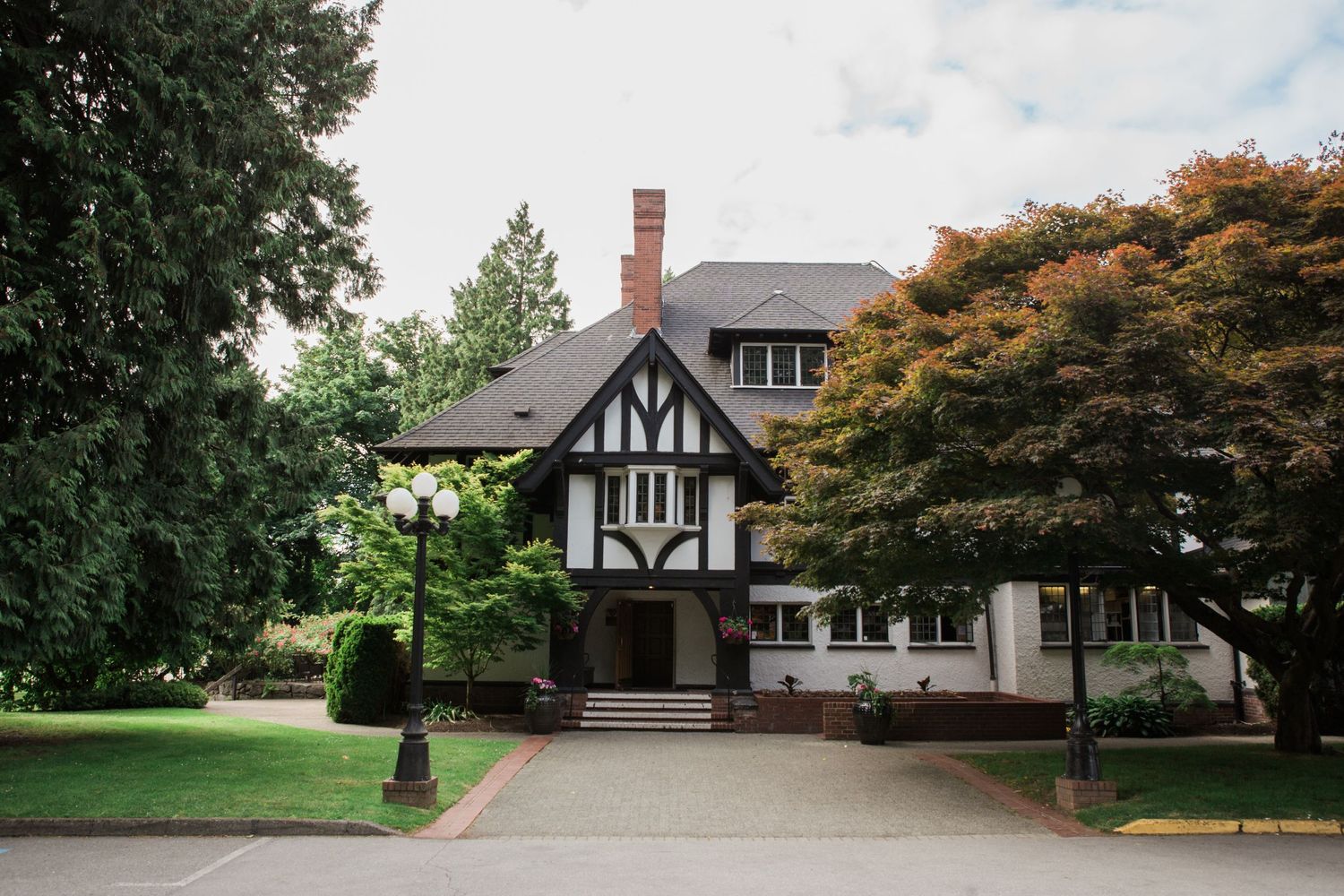 A charming Tudor-style house with distinctive timber framing and mature trees in the landscaping.