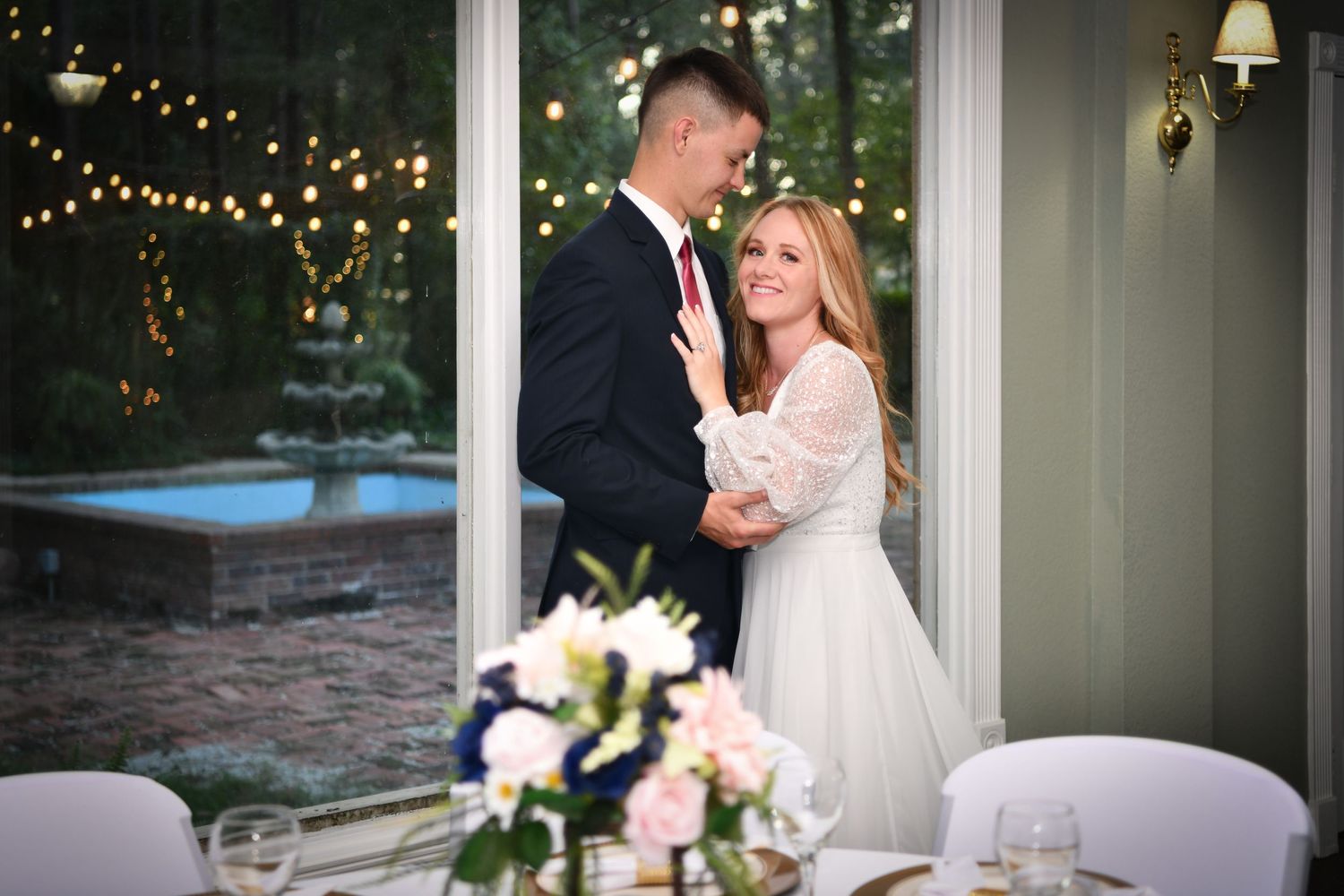 Bride and groom with window looking out to courtyard