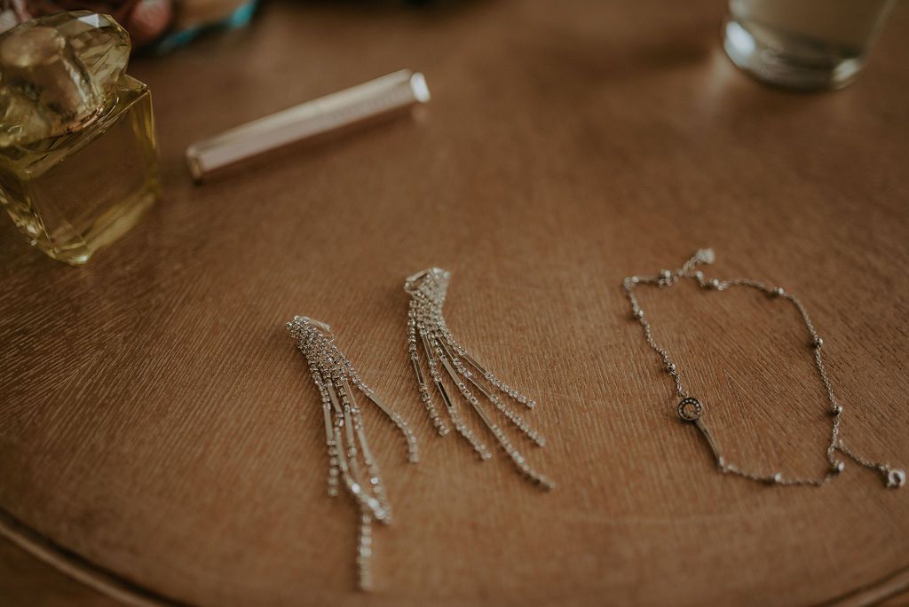 Elegant crystal jewelry and accessories laid out on a wooden surface in preparation for a special occasion.