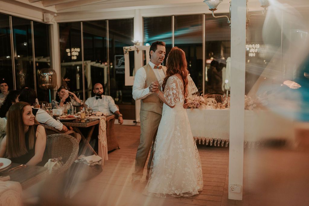 Wedding reception venue with romantic lighting and dancing couples.