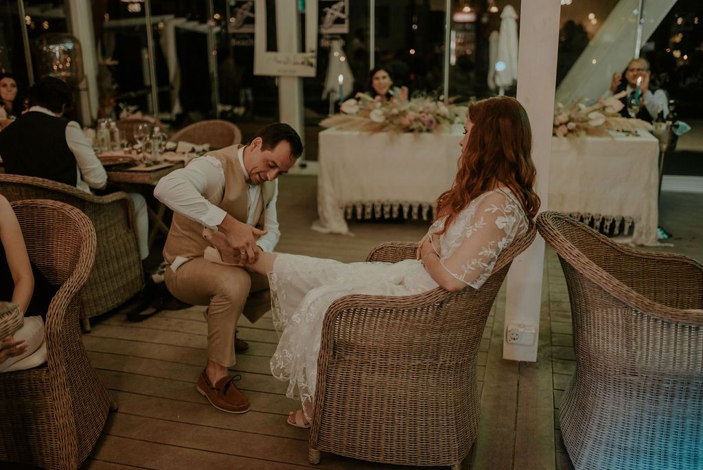 Guests relax in wicker chairs during an evening wedding reception.