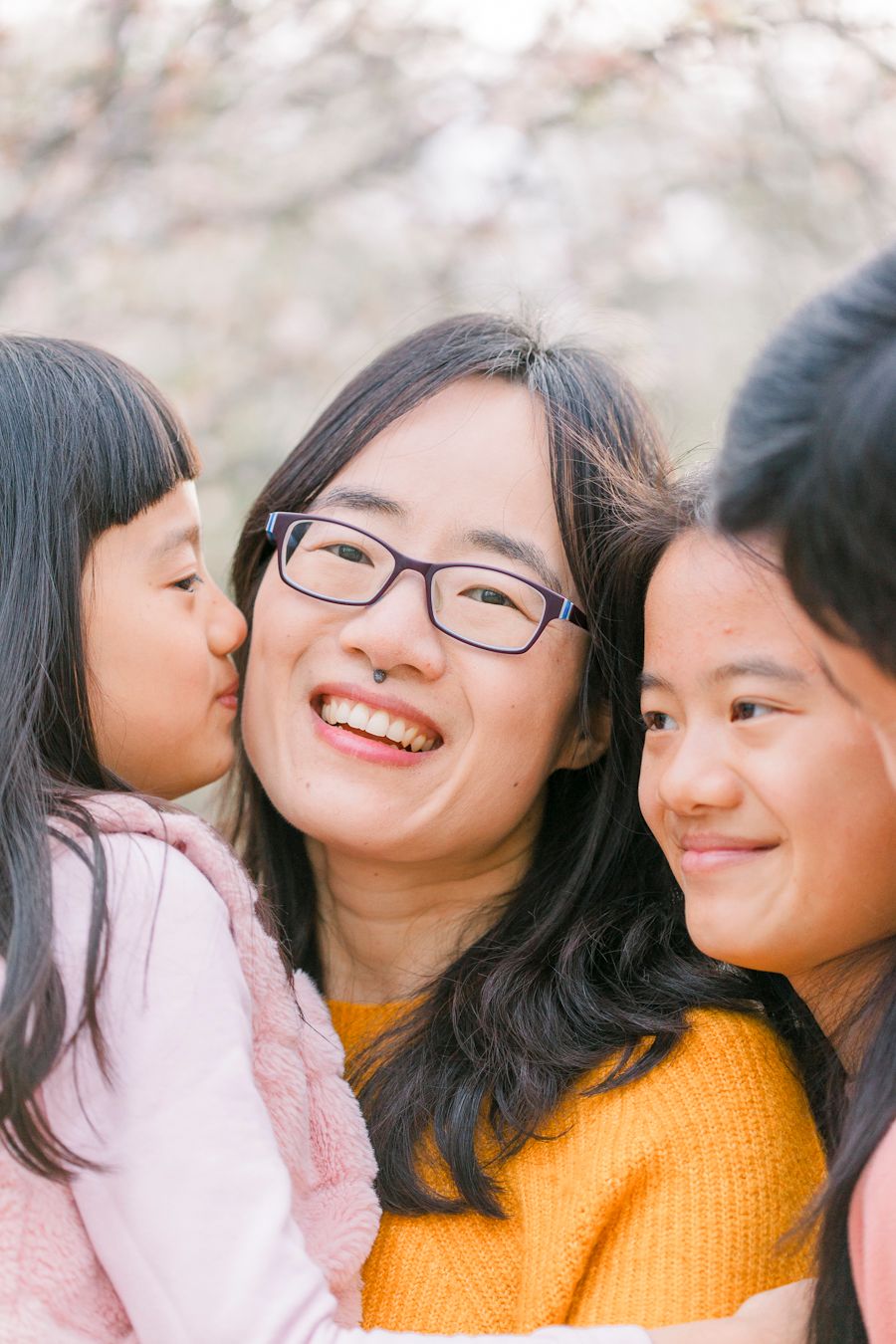 Three people sharing a joyful moment together outdoors in spring.
