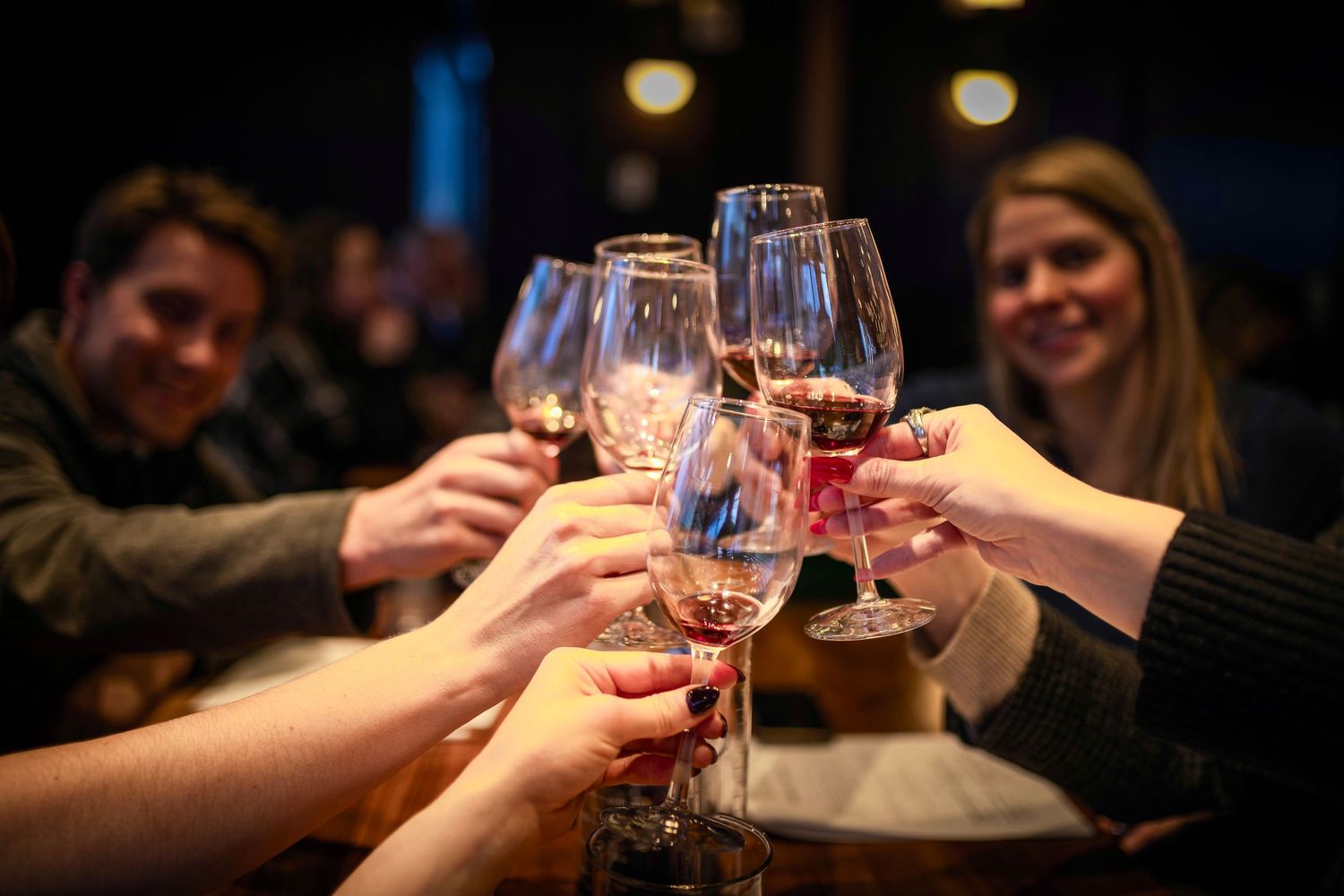 Friends raising wine glasses in a toast during a celebratory gathering.