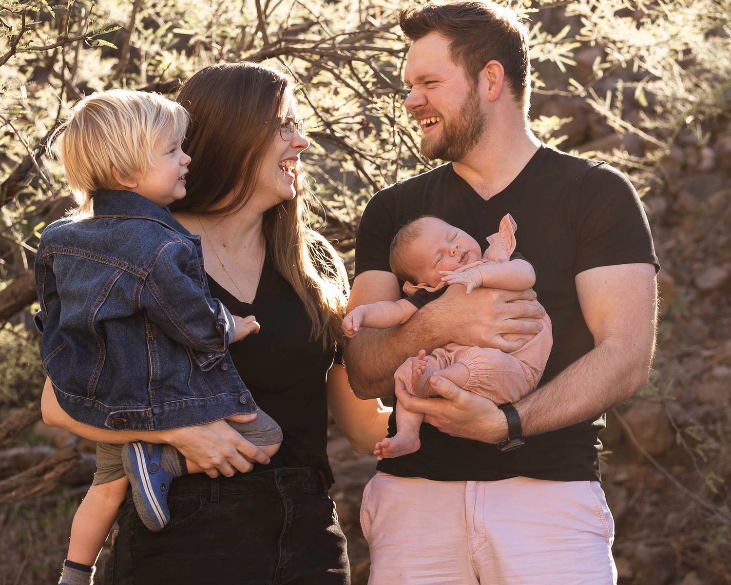 Loving family moment captured outdoors in warm golden sunlight.