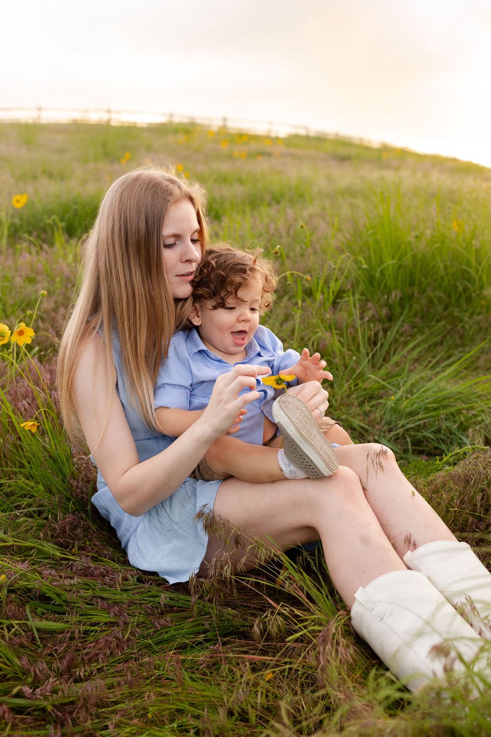 Playful interactions between family members as they relax in a grassy meadow with yellow flowers.