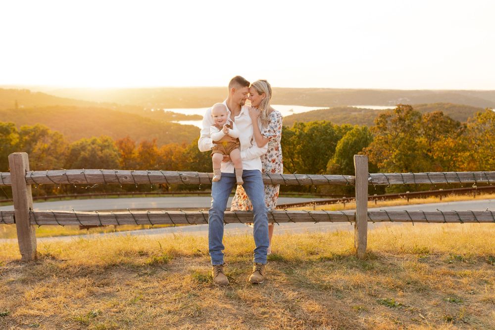 Two people embracing on hilltop during autumn sunset with lake view.