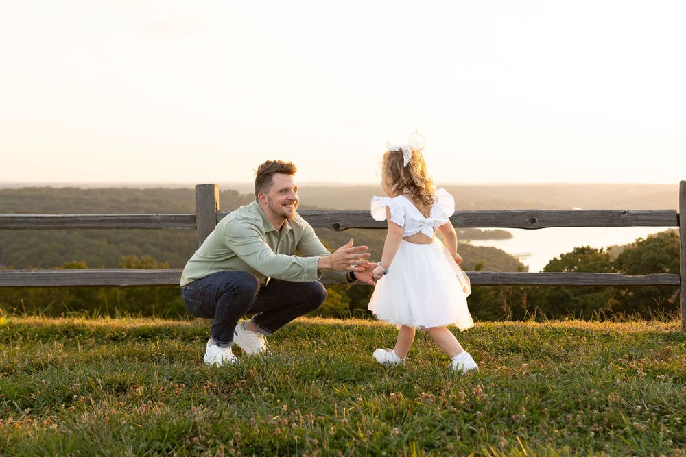 Heartwarming interaction on grassy hilltop during sunset.