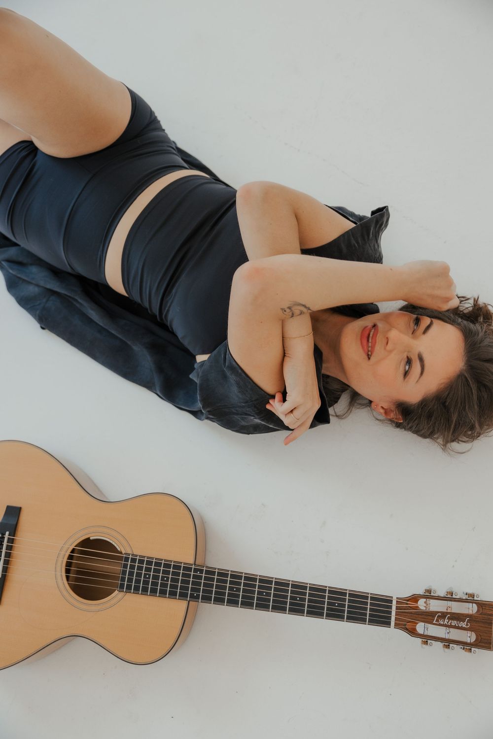 Artistic portrait with acoustic guitar showing relaxed poses on light background.