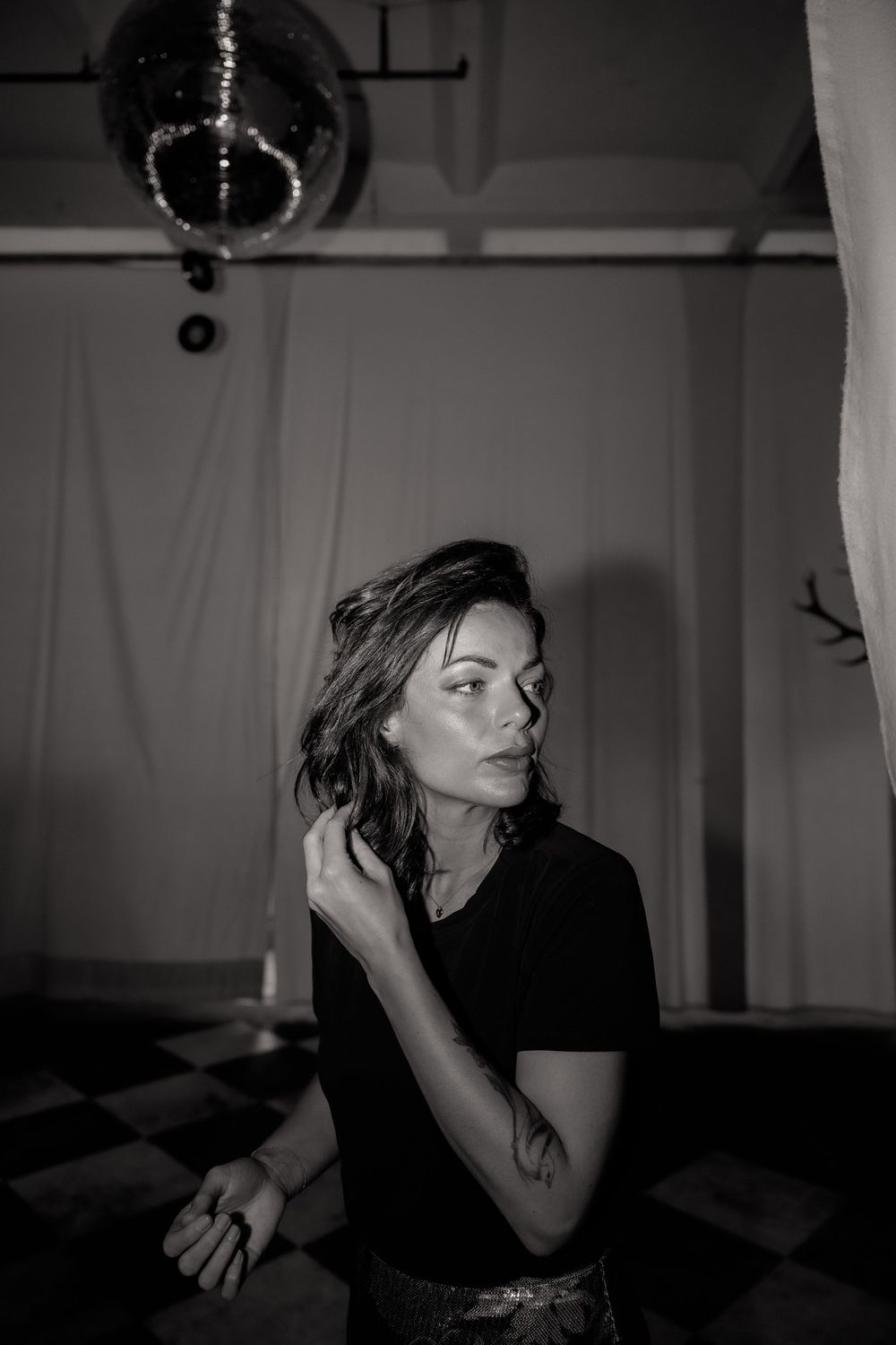 Dramatic black and white photo series of person dancing in moody lighting with disco ball.