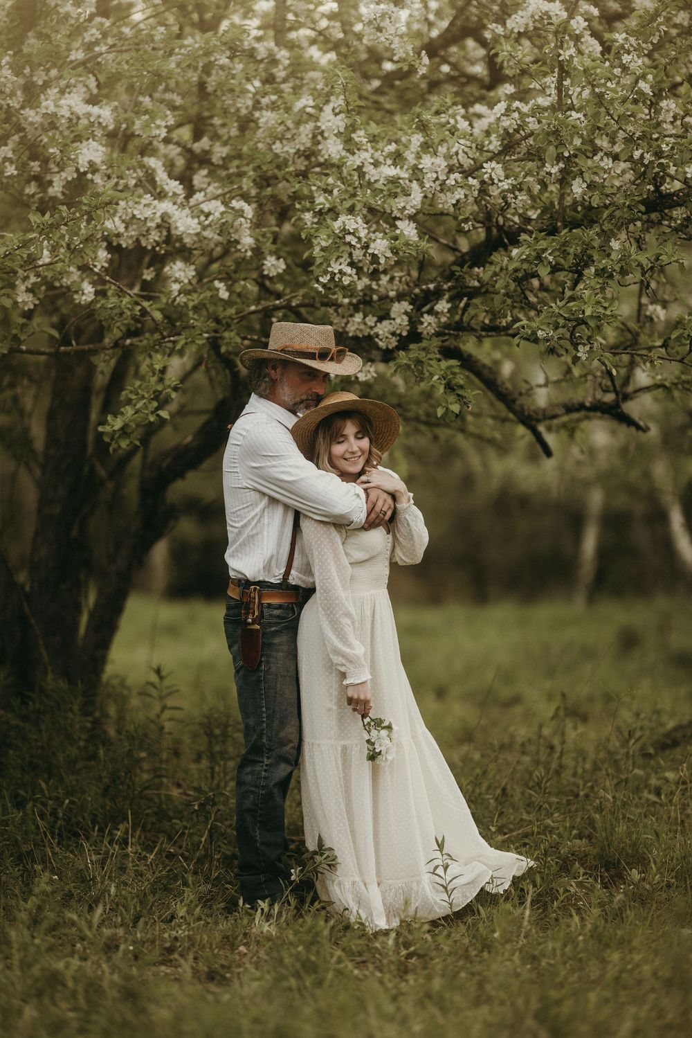 Romantic dance sequence captured in blooming spring orchard.