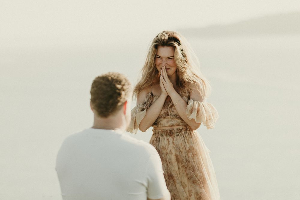 A romantic proposal moment captured against a misty natural backdrop.