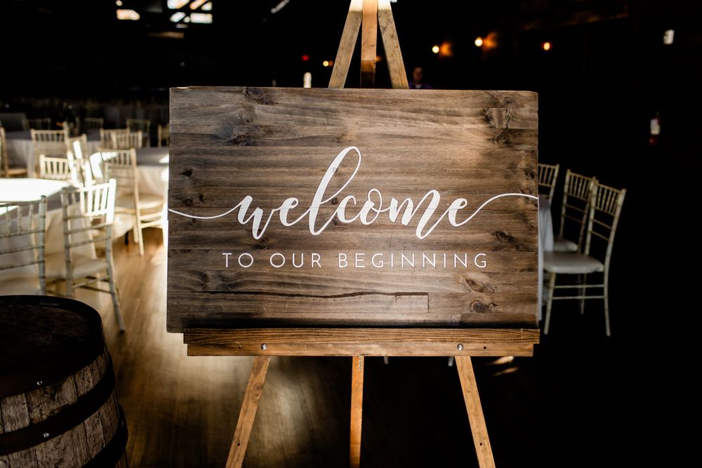 Wooden welcome signs on easels at rustic wedding reception.