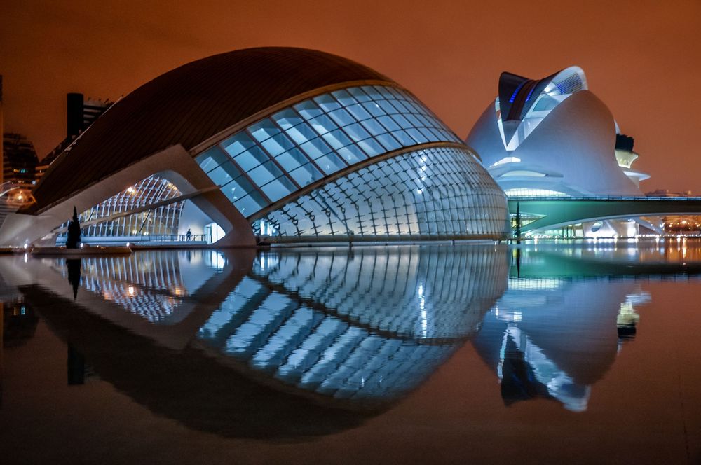 Futuristic City of Arts and Sciences in Valencia illuminated at night with stunning reflections on water.