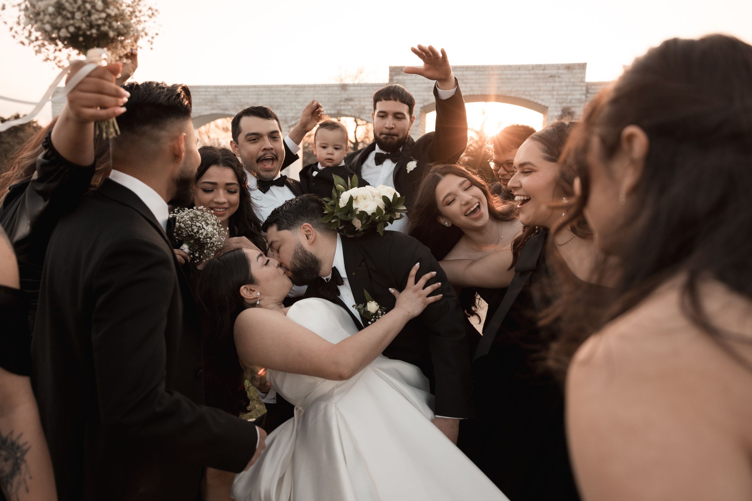 Lively crowd of wedding guests dancing and celebrating at an evening reception.