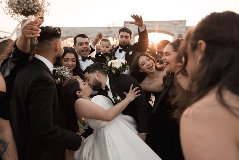 Lively crowd of wedding guests dancing and celebrating at an evening reception.