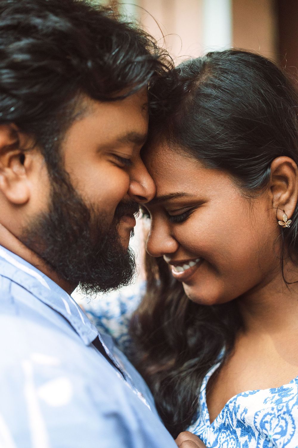 A couple shares an intimate close-up moment while smiling.
