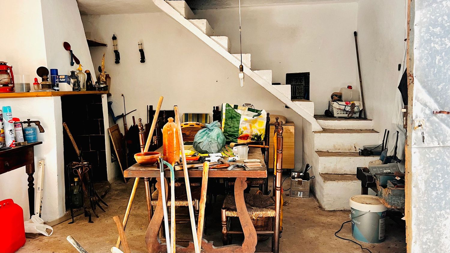 A panoramic view of an artist's studio space with white walls, artwork displays, and natural lighting from windows.