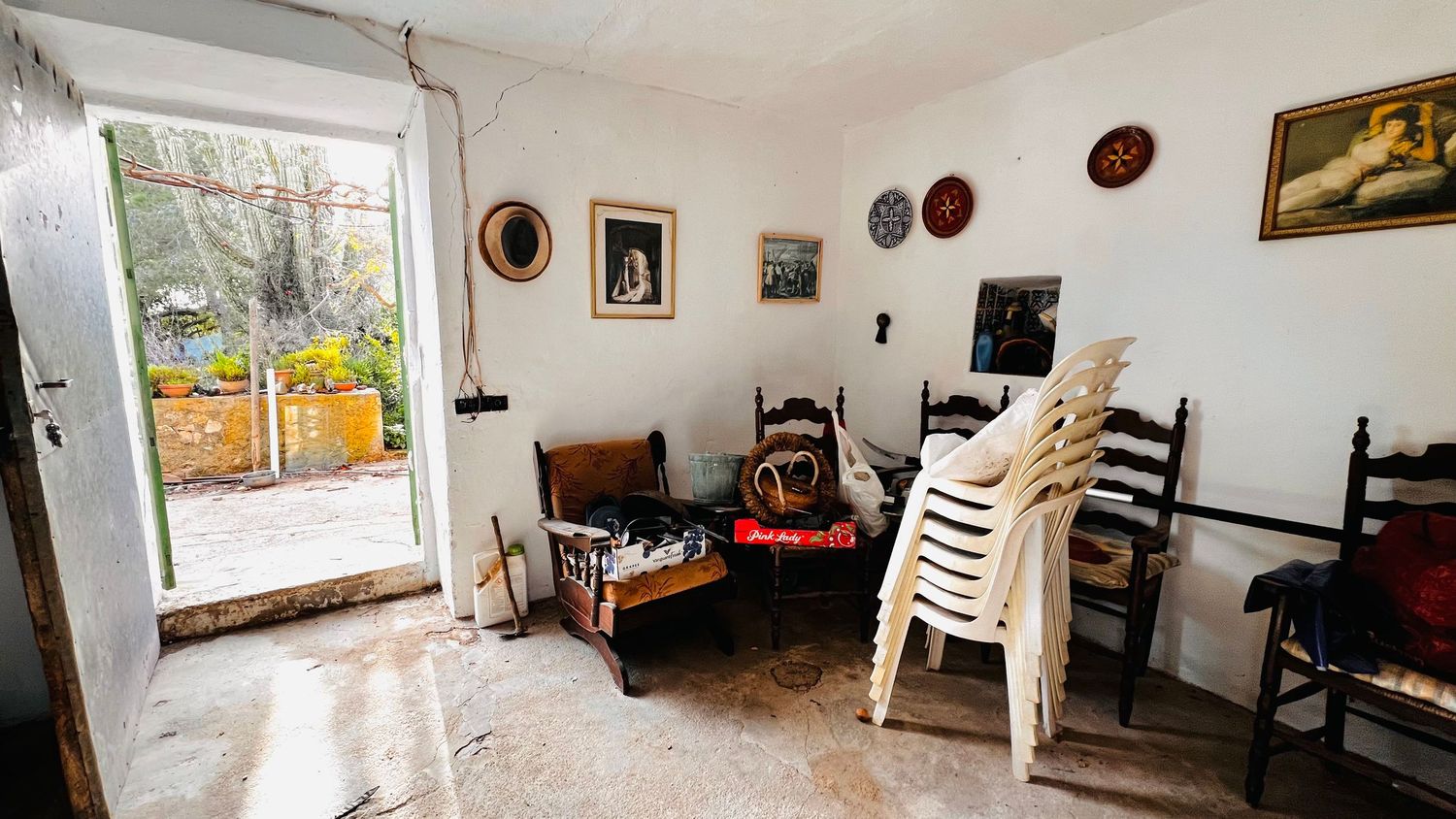 A wide-angle interior shot of a bright art studio with paintings, easels, and decorative items along the walls.