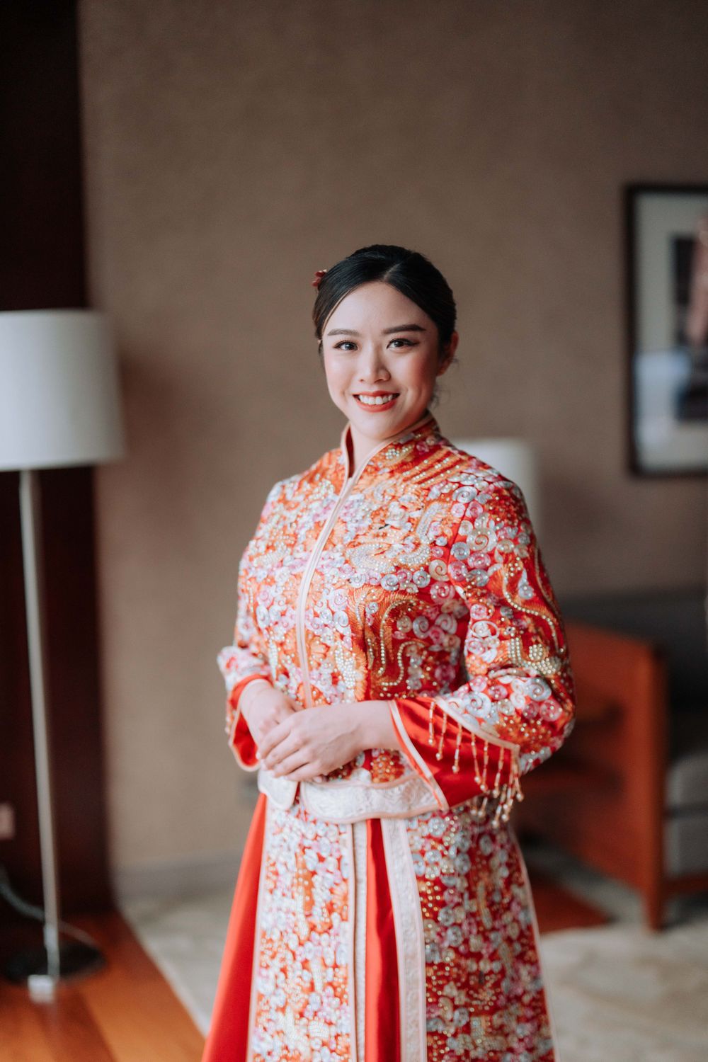 A close-up portrait of someone in an ornate red and white traditional Chinese wedding dress.